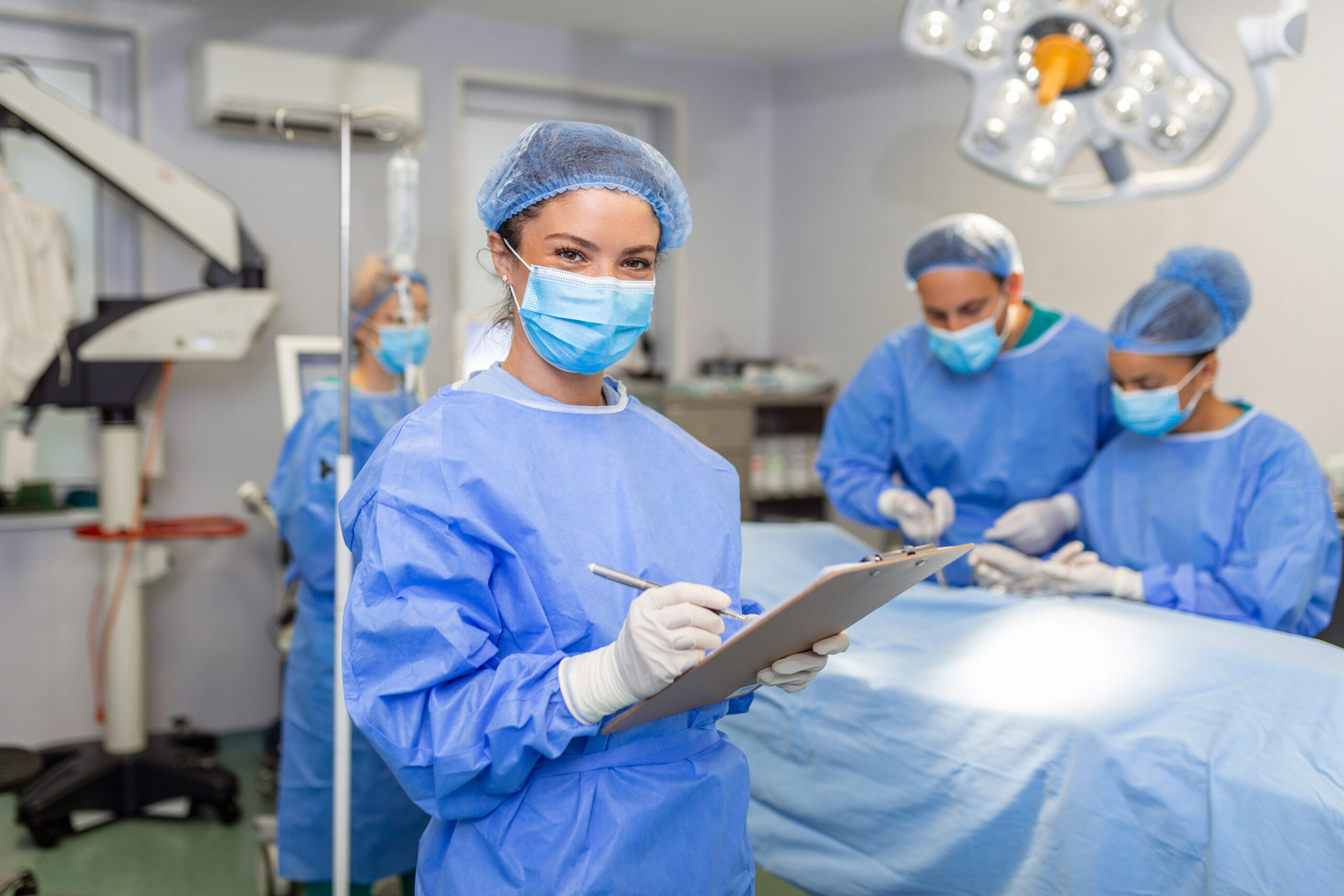 Surgeon writing on a clipboard in an operating room