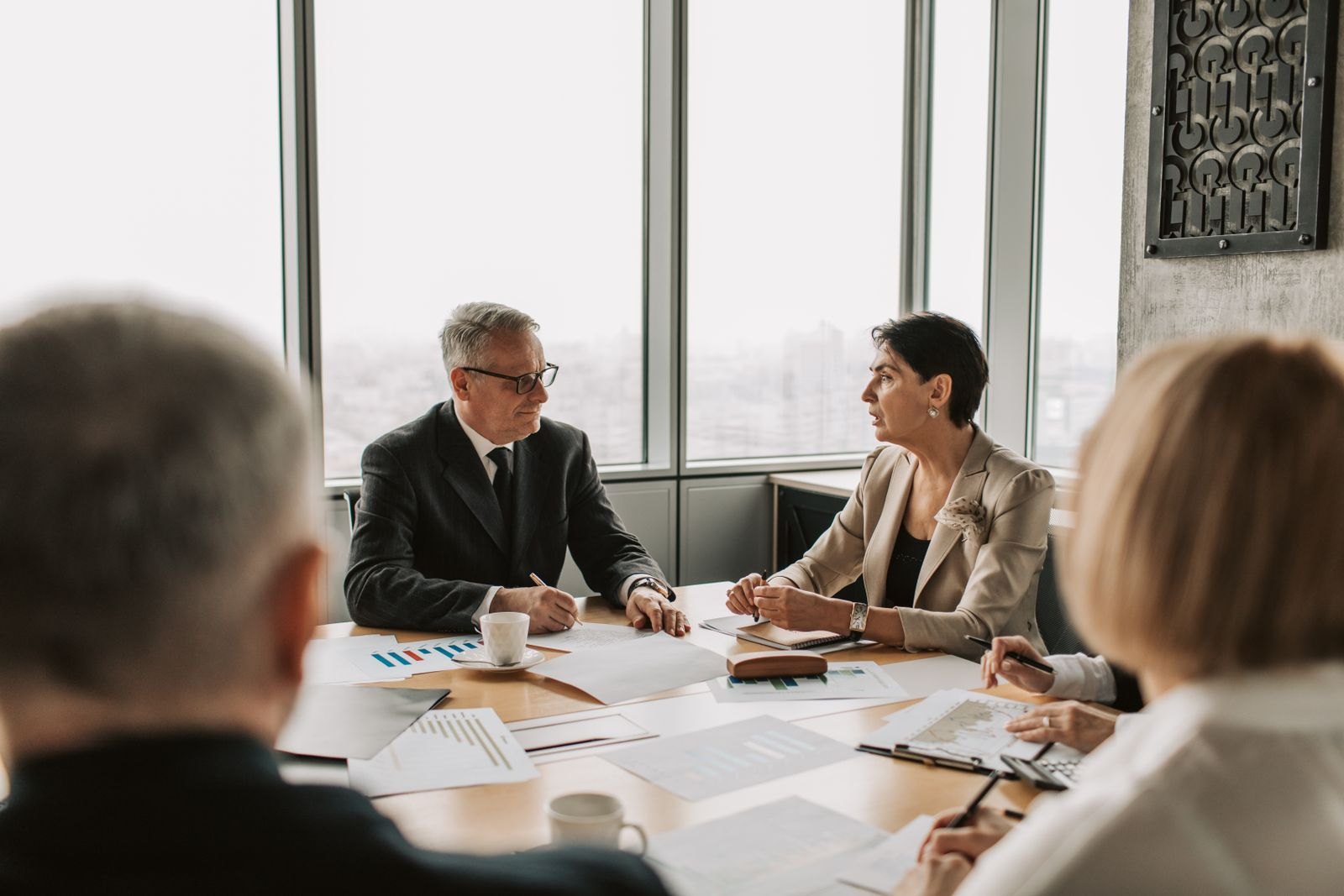 Healthcare executives reviewing partnership documents around a boardroom table