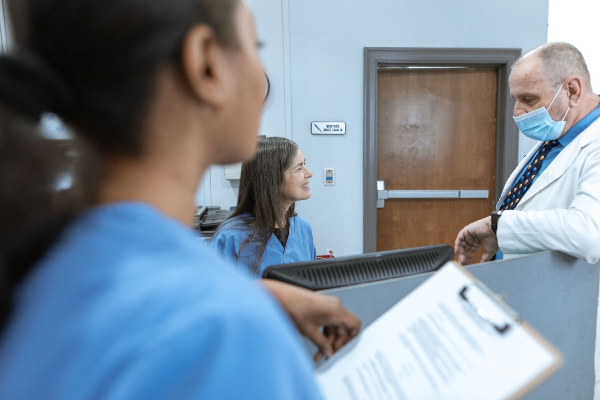 Healthcare professionals in discussion in a clinical corridor