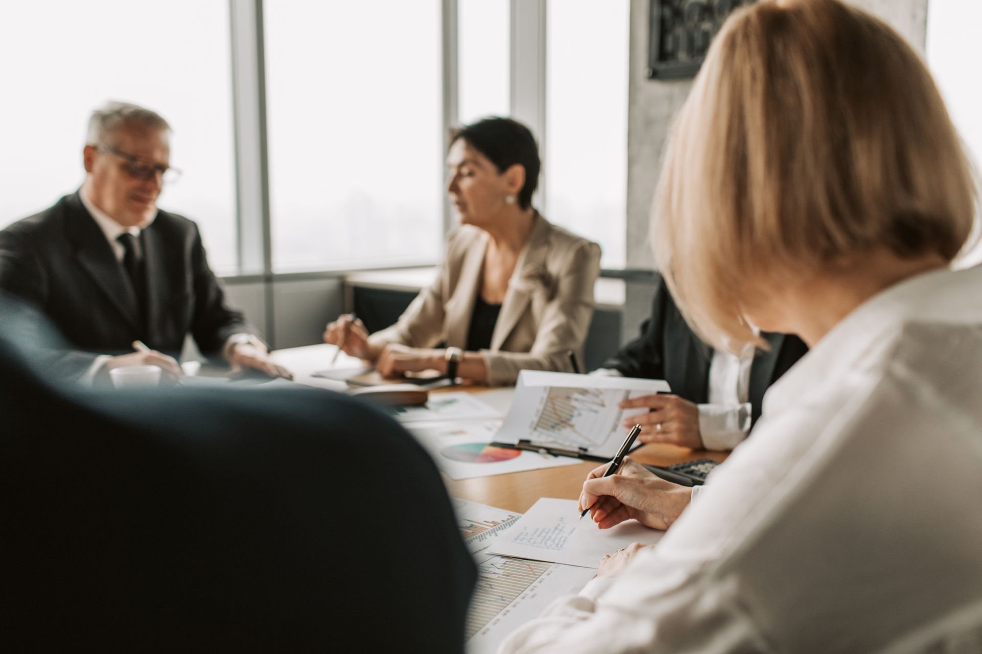 Colleagues reviewing contract documents around a boardroom table