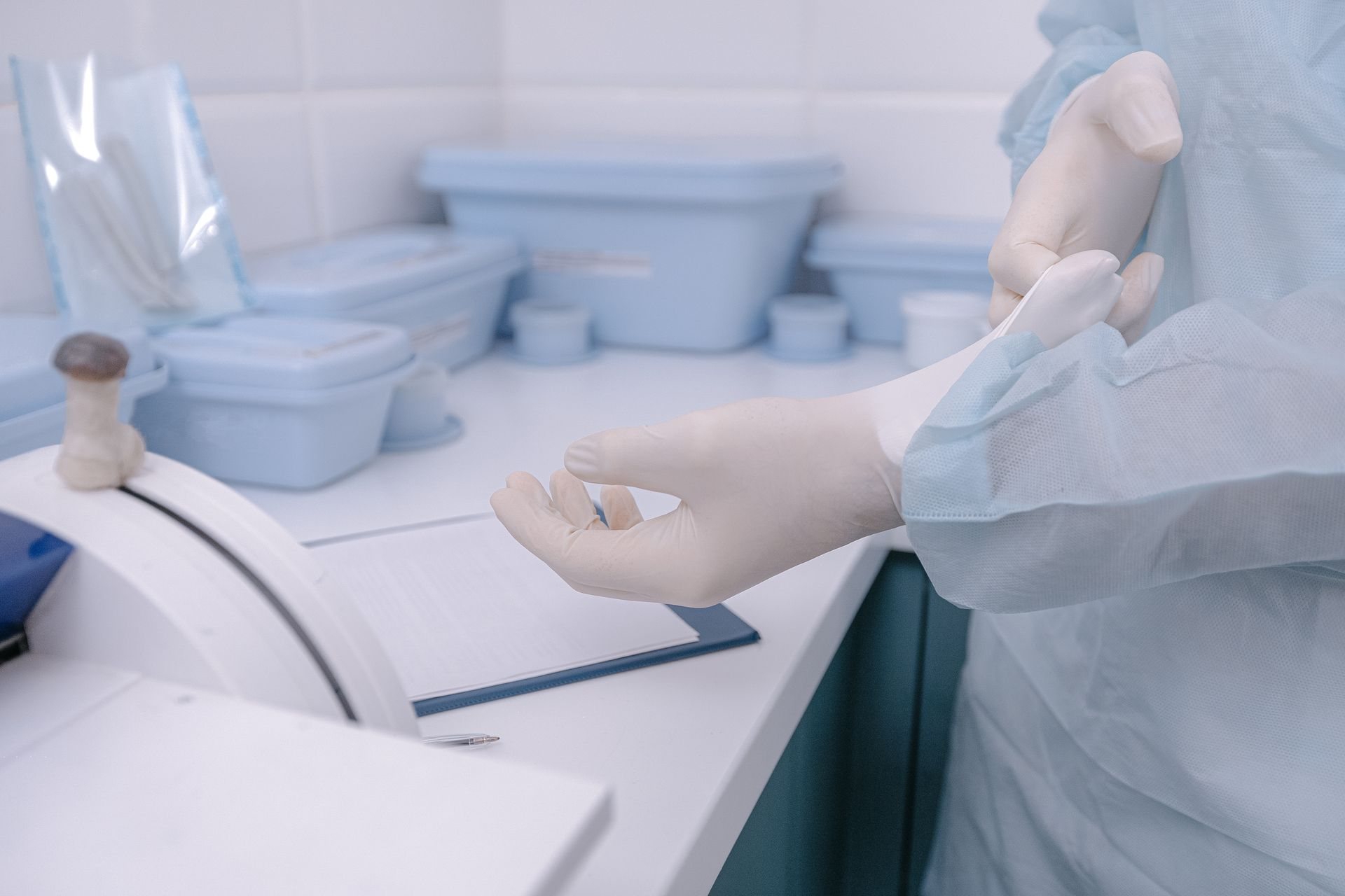 Health worker putting on gloves in a sterile preparation area