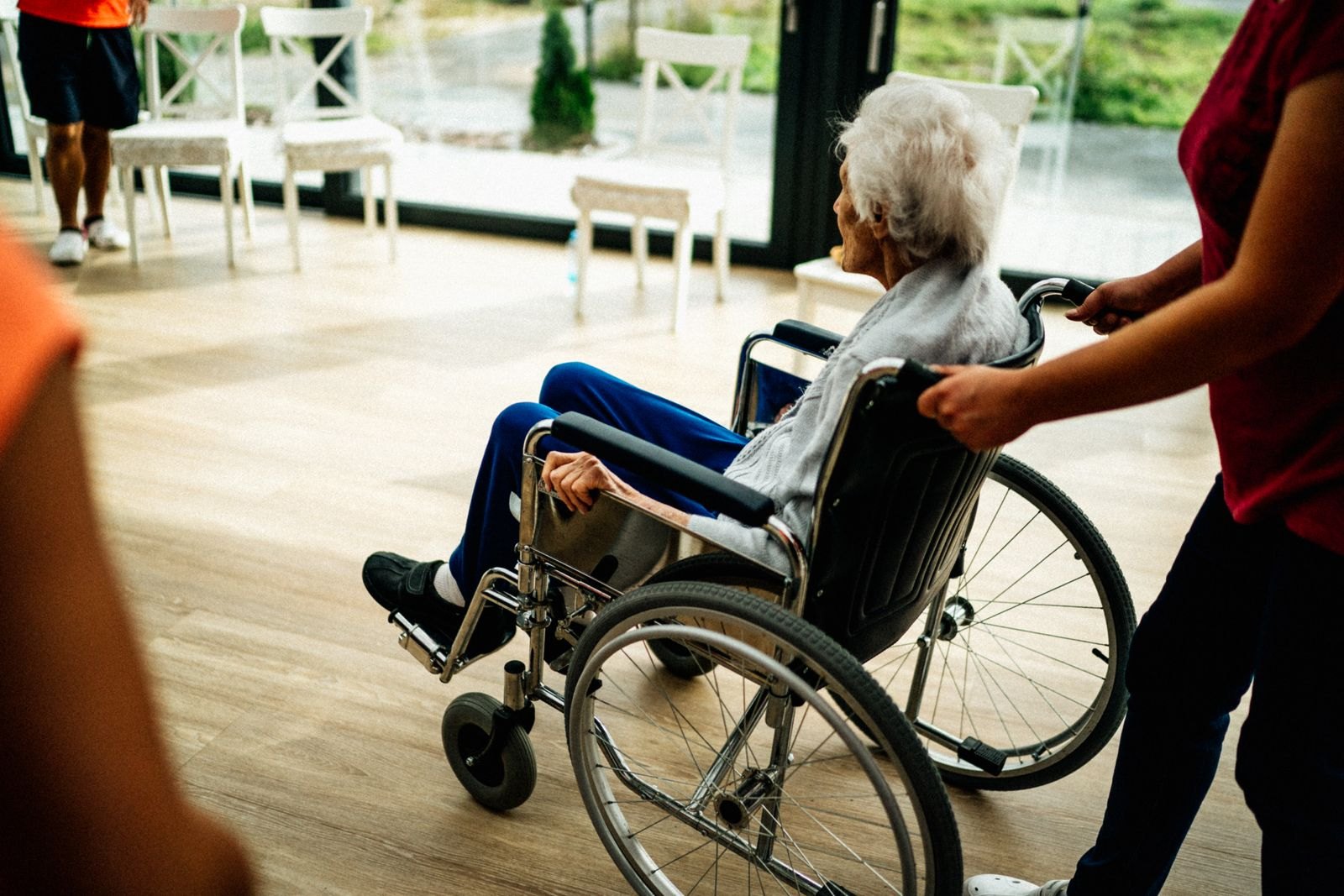 Caregiver assisting a senior resident in a bright long-term care facility